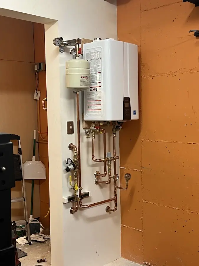 Plumbing technician inspecting water heater connections in Prairie View